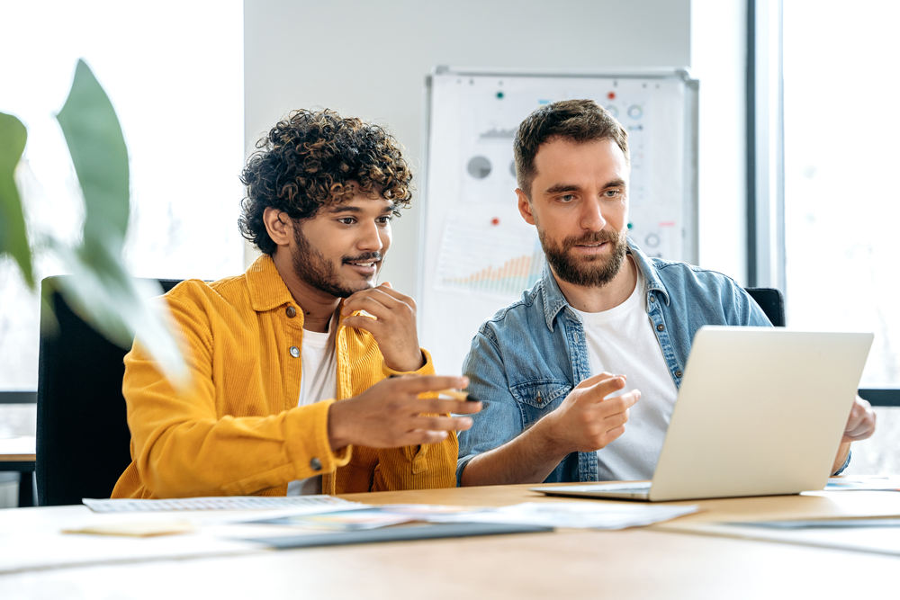 Two men looking at a laptop