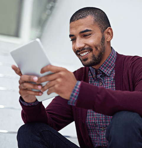 Man smiling looking at a tablet