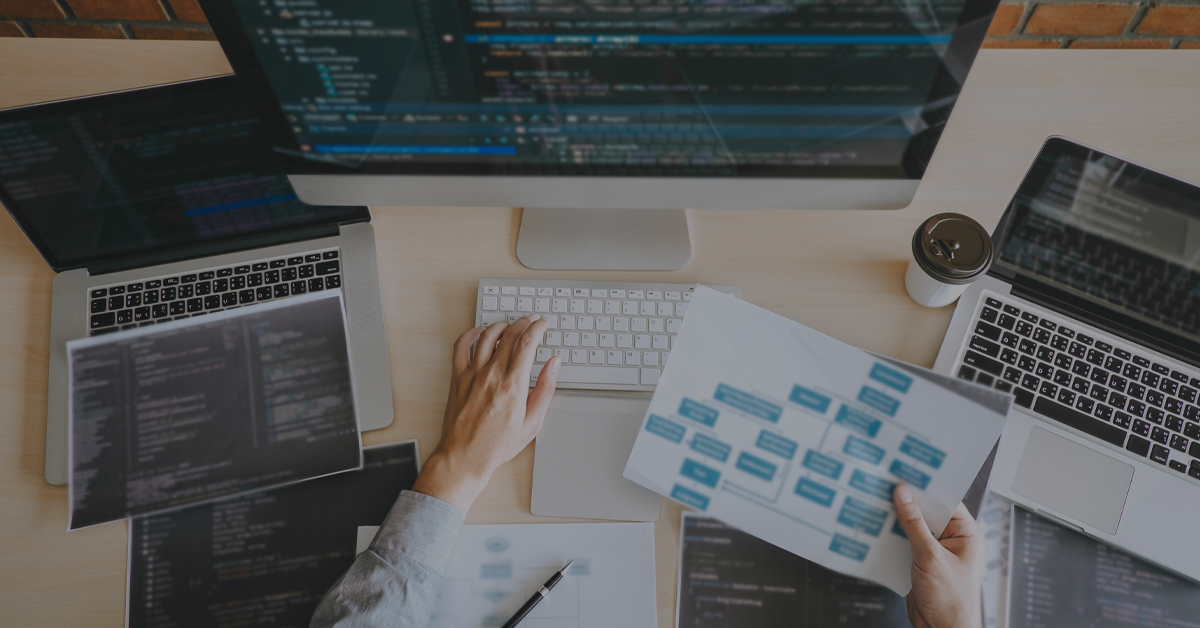 What is composable commerce?  Multiple computers, coding and algorithm decisions maps over a desk. 